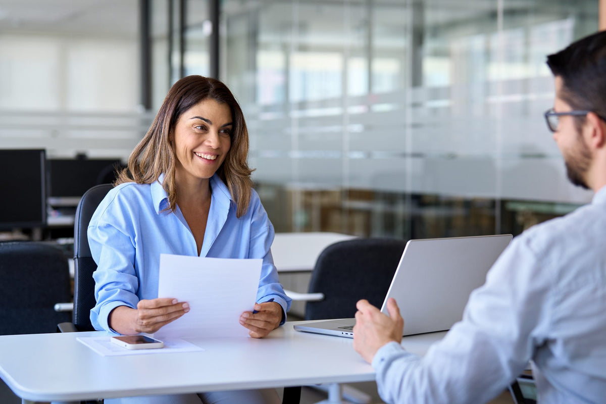 A Lewis Medix coordinator smiles as she reviews a care plan with a client
